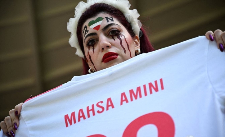 Police officers confiscate an Iran fan’s ’Women Life Freedom’ flag inside the stadium